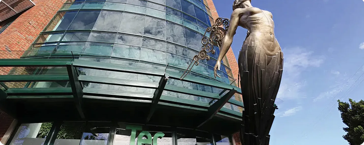 Escultura moderna frente a un edificio de vidrio en Kendall Reserve, representando la conexión entre arte y comunidad.