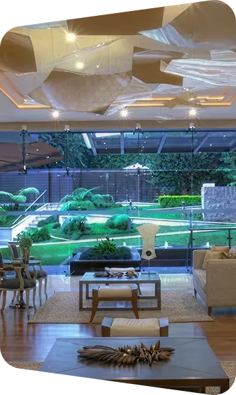 Vista interior de un moderno salón en Kendall Reserve, con acceso a un jardín verde y bien cuidado, ideal